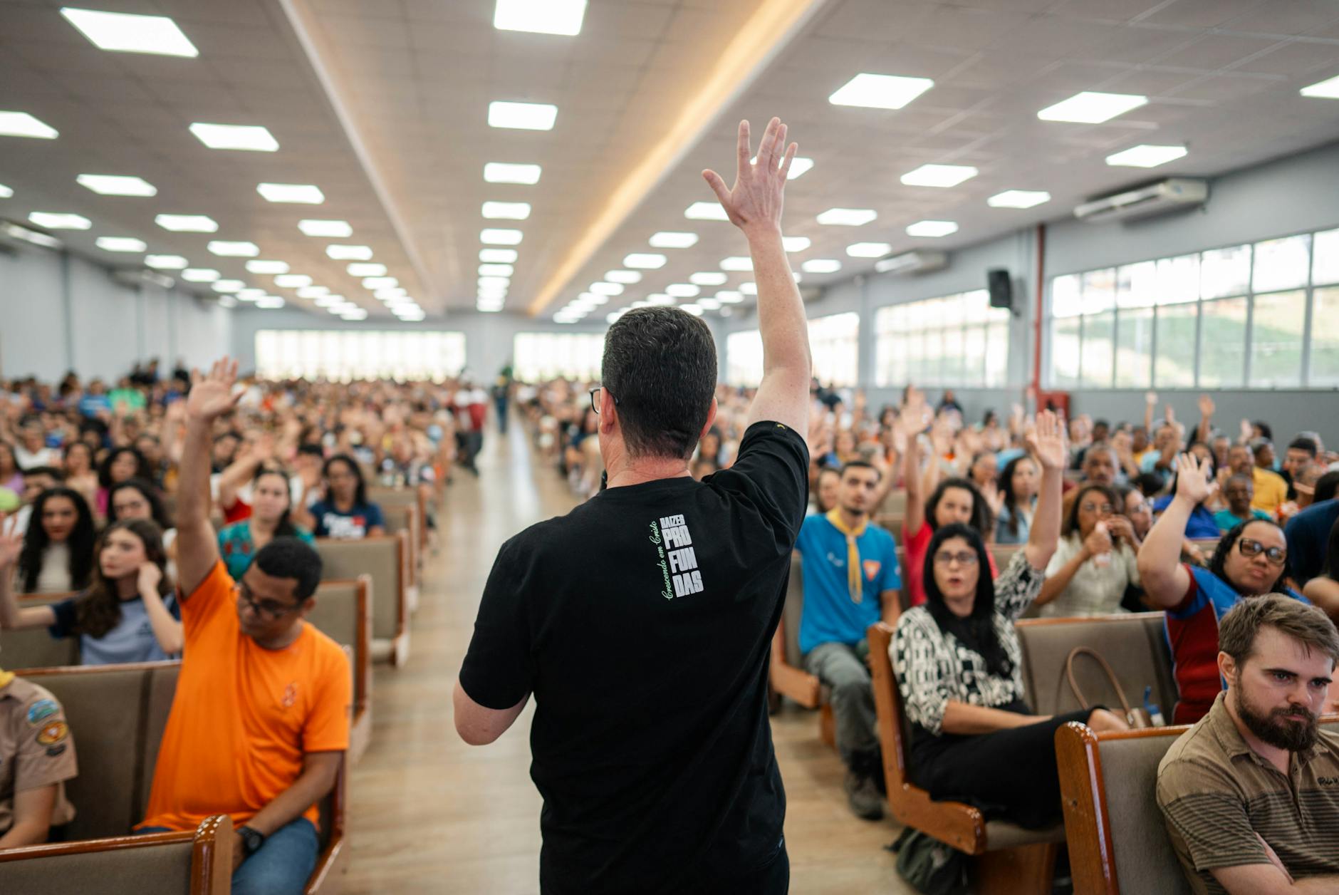 An audience participating actively during a debate, raising hands to ask questions. — engaging debate audience